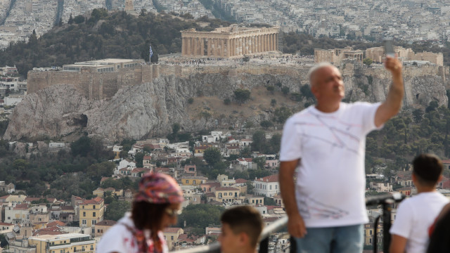 The Parthenon is seen in the background as tourists take in the view from Lycabettus Hill in Athens, Greece, 04 August 2024